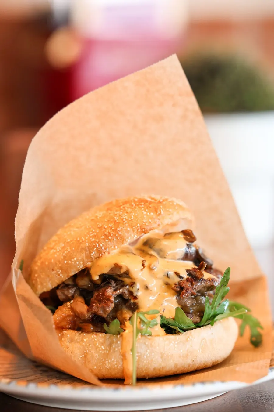 Double burger wrapped in paper on a plate
