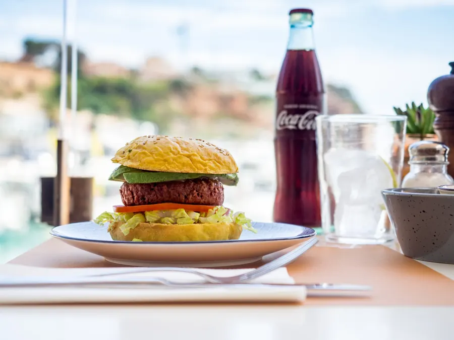 Vegan beetroot burger served on the terrace with the boats in the background