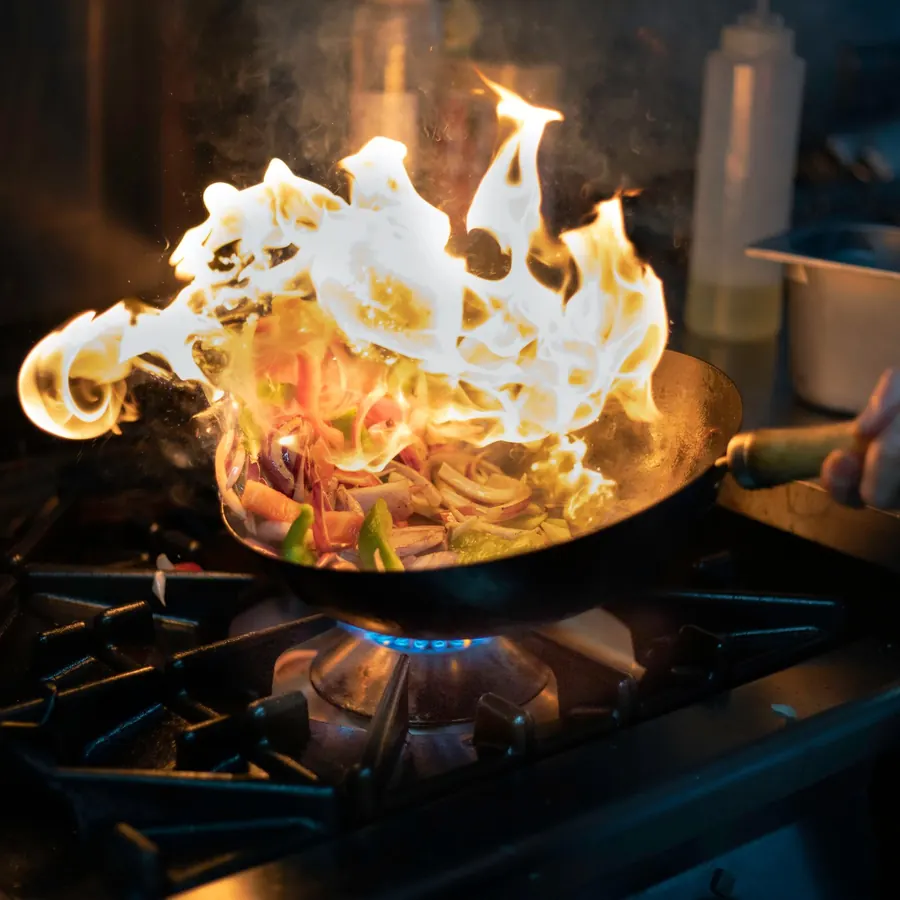 A flambéed stir-fry in the kitchen
