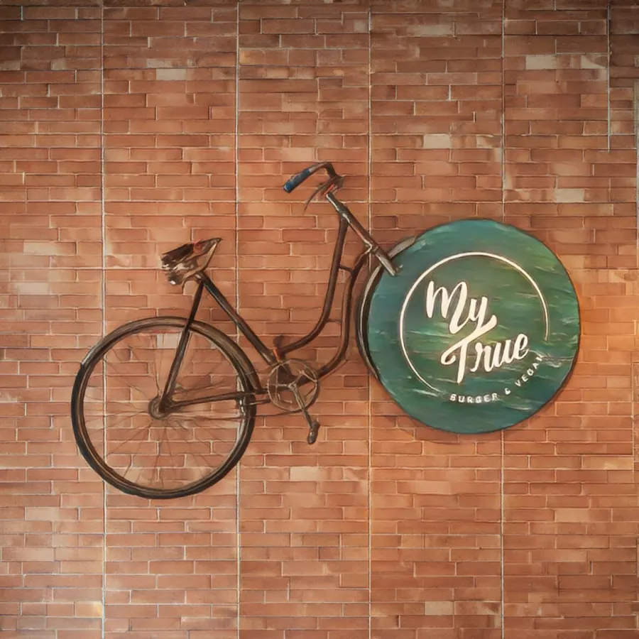 The My True logo on the brick wall beside a bicycle